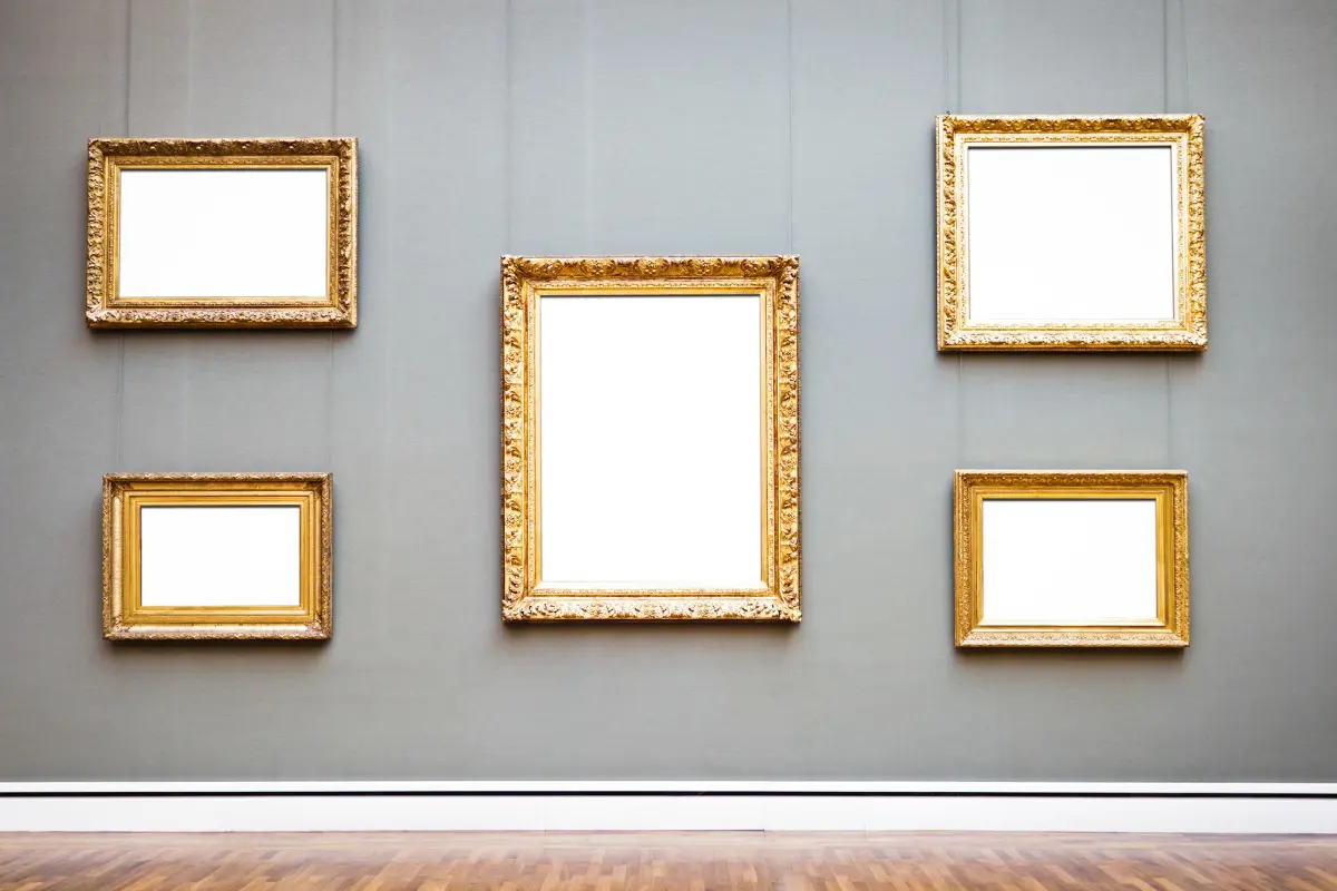 Empty gold frames on a gallery wall.